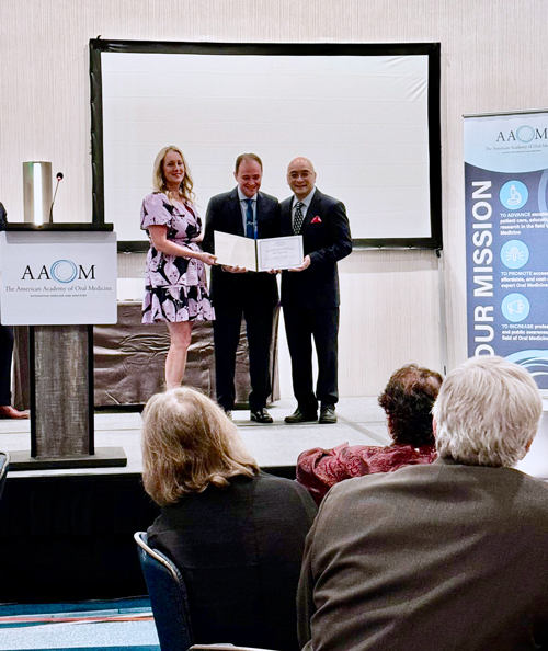 O professor Alan Silva (ao centro), ao receber a distinção dutante a 2024 AAOM Annual Conference, realizada em Orlando, Florida